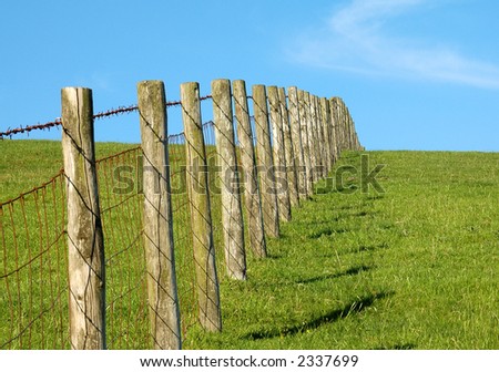 Post and wire fence on a grassy hill