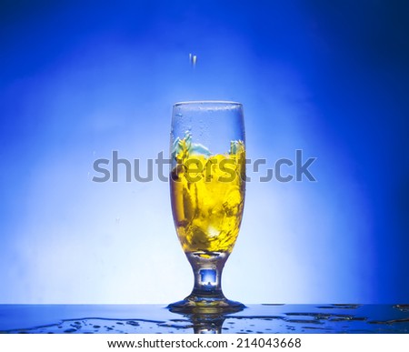 splash glass withe yellow liquid blue background