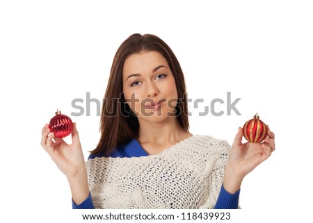 Young girl having hard times choosing Christmas decoration