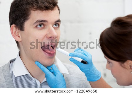 Doctor is checking throat of a patient