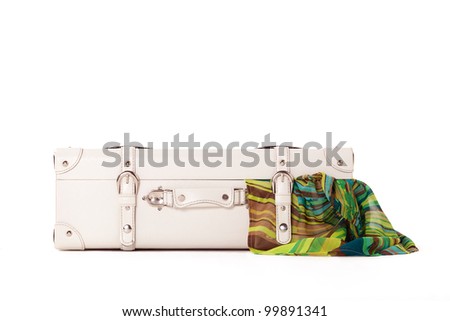 White suitcase on white background, standing on white surface with dress sticked out