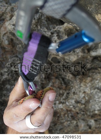 Rock climber grabbing a quick-draw