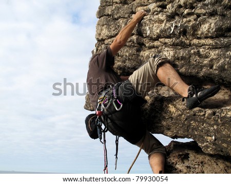 Rock climber on a cliff practicing traditional rock climbing