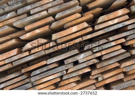 Wooded boards stacked at a lumber yard in a village.