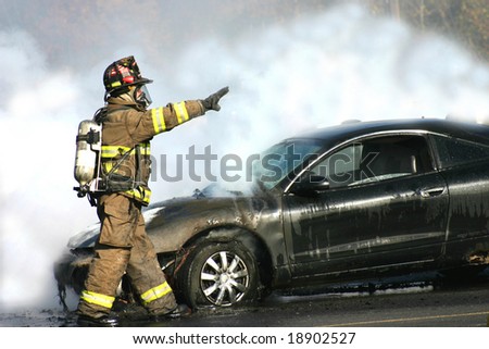 Fireman engulfed in smoke from a car fire.