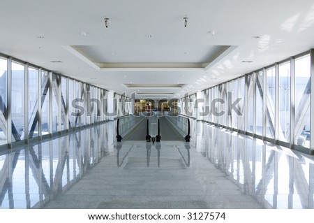 glass wall modern passage  with moving staircase