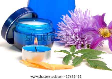 blue cosmetic cream,lotion, candle, flower on white