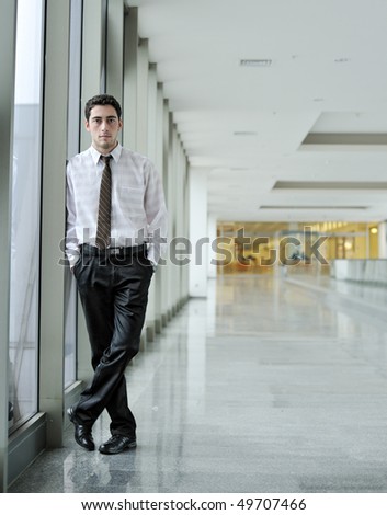 handsome young man in  business suit standing in  office environment