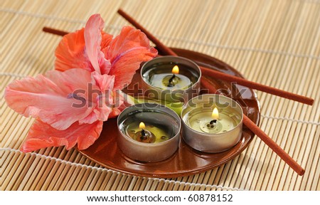 scented candles with gladiolus and incense stick on ceramic plate