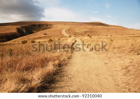 uphill path between yellow hills