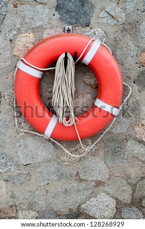 Life buoy ring hanging on rock wall