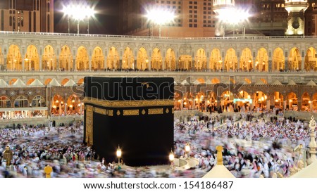 Kaaba In Mecca, Saudi Arabia. Muslim Pilgrims, From All Around The World, Revolving Around At Night.