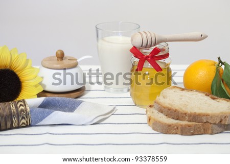 A healthy breakfast with milk, honey, bread and fruit