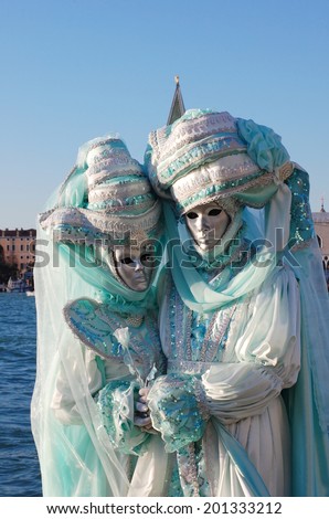 VENICE, ITALY - FEBRUARY 24: The carnival of Venice is held in Italy. Beautiful couple in colorful costumes and masks, view on Piazza San Marco. Wonder and Fantasy Nature. Venice, Italy - Feb 24, 2014