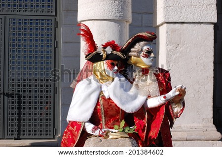 VENICE, ITALY - FEBRUARY 24: The carnival of Venice is held in Italy. Beautiful couple in colorful costumes and masks, Santa Maria della Salute. Wonder and Fantasy Nature. Venice, Italy - Feb 24, 2014