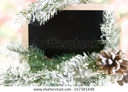 Empty blackboard with snowy Christmas tree and bokeh background