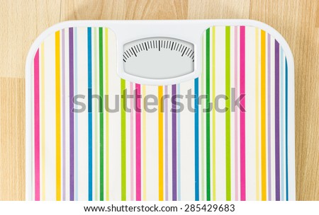 Bathroom scale with clean dial with lines no numbers on wooden floor