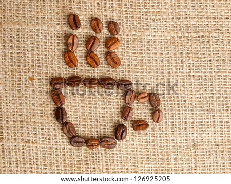 Coffee bean coffecup icon on jute background.