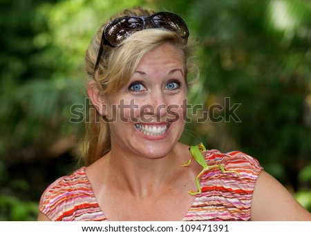 Scared woman with a frog crawling on her shoulder Red-eyed Tree Frog in Costa Rica jungle