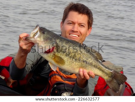 Man in a float tube or belly boat with a big Largemouth Bass