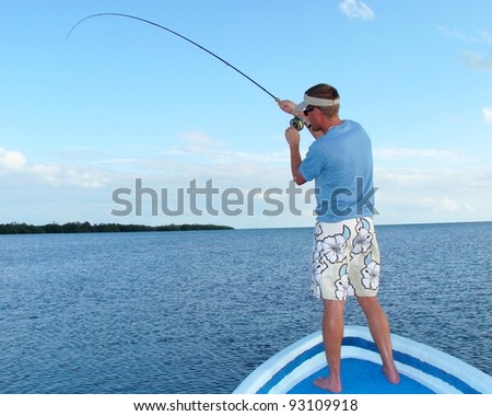 Saltwater fly fishing for bonefish - Fighting a big fish in the ocean off the front of a boat