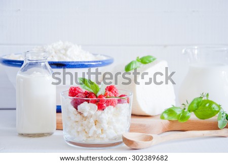 Dairy assortment: Cottage Cheese with red berries, Cheese, yogurt, cream, sour cream, milk.