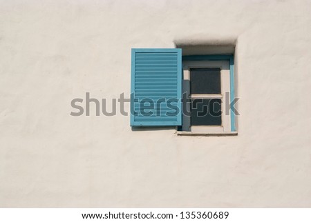 Light and shadow across on the blue window and the white wall.