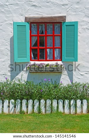 Red & Blue Window with flower pots on the white wall background.