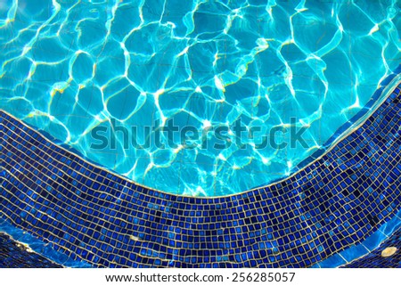Blue tiles of jacuzzi in the Swimming pool blue water and sunlight reflection effect