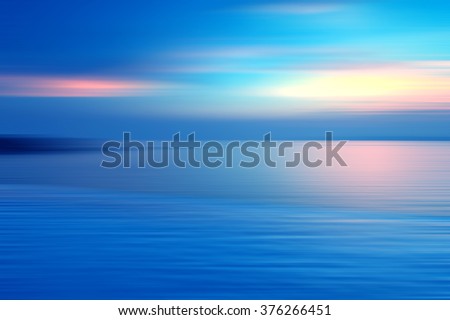 Motion blurred background of refraction in water. Panoramic dramatic view of Infinity sunset on the sea at twilight times.