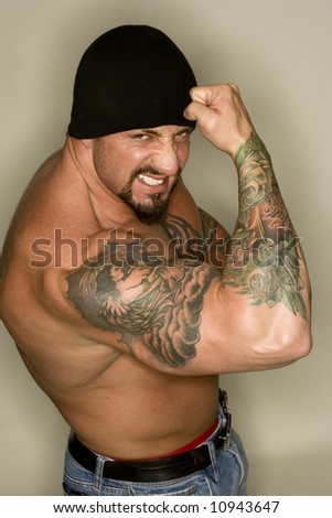 stock photo : Tattooed man posing with flexed biceps.