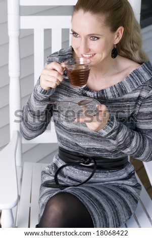 Woman sitting on porch enjoying a cup of tea.