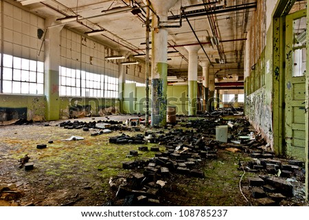 Lots of green mold on the floor of an abandoned factory.