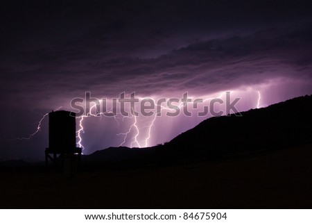 Lightning strikes in the mountains behind an abandoned water tower at Dos Cabezas Siding in the Anza-Borrego Desert.