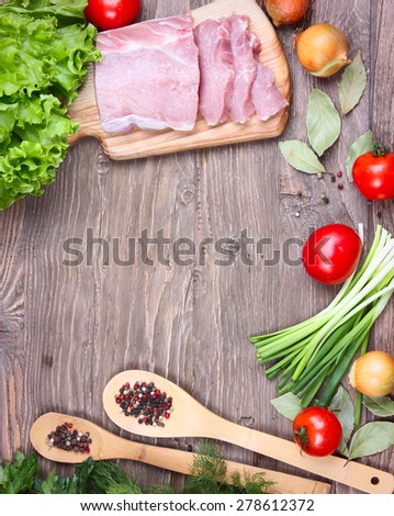 fresh pork and fresh herbs on wooden background