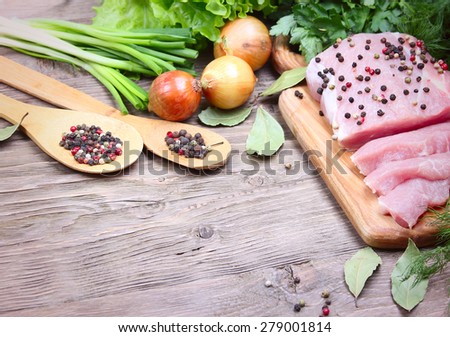 fresh pork and fresh herbs on wooden background