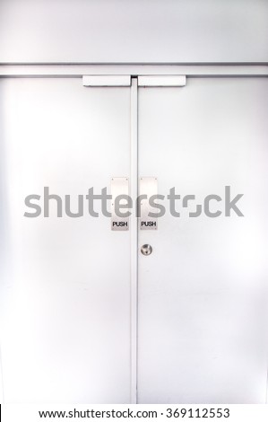 two flush doors with metallic push sign and door knob