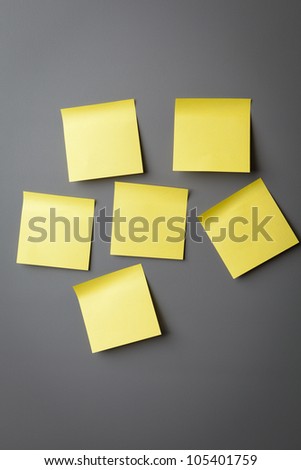 Yellow sticky notes on a grey wall
