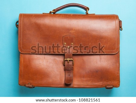 A vintage leather briefcase on a blue background