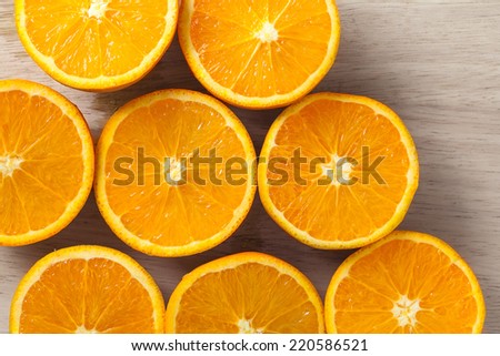 Macro photograph of a bunch of oranges cut in half, set on wooden board