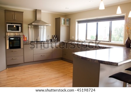 A large modern kitchen with stainless steel accessories and wooden floor