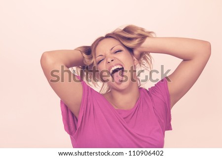 Crazy humorous girl portrait, pulling hair braids sticking tongue out