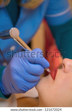 Cosmetologist making permanent makeup on woman\'s face