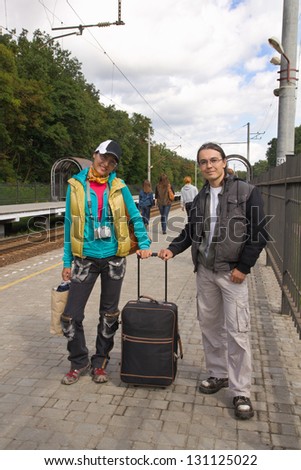 Man and woman with baggage waiting for train
