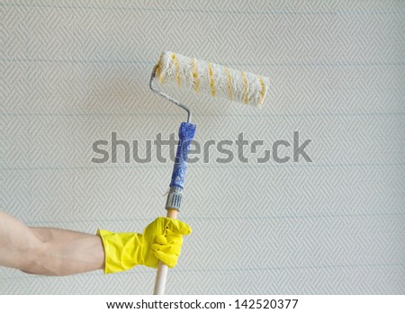 Close up of hand of house painter worker with painting roller