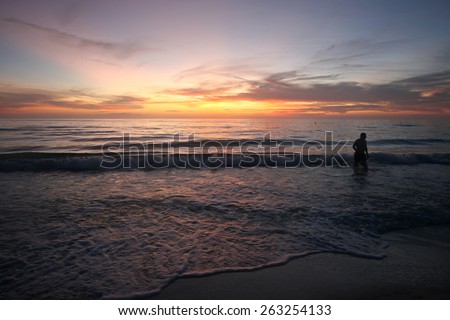 A stunning sunset over the ocean with person gazing