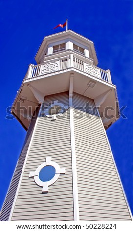 A lighthouse with pure blue sky upward view.