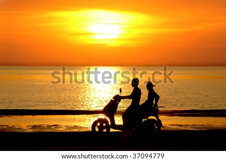 Silhouette two young people go on motor scooter on sundown