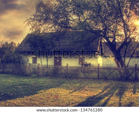 Vintage landscape with autumn forest and little house in sunset.