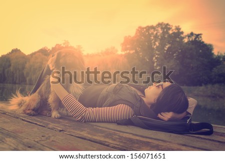 Vintage photo of relaxing woman with her dog on a pier